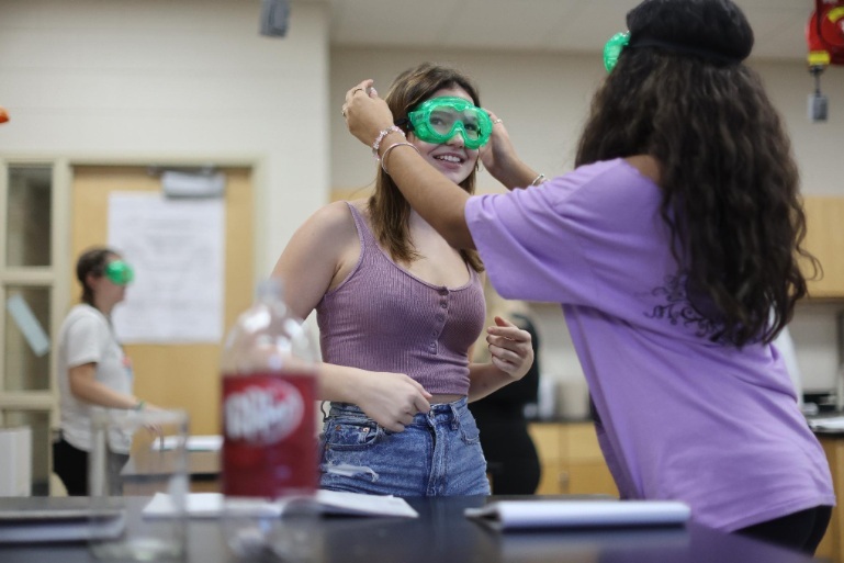 Students wearing safety goggles in a science class