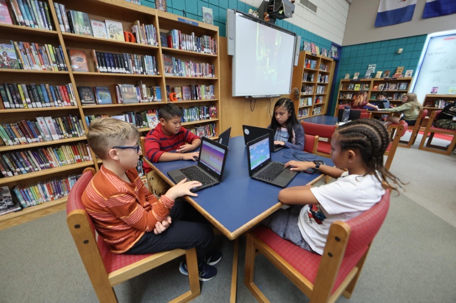 Students using Chromebooks in a school library